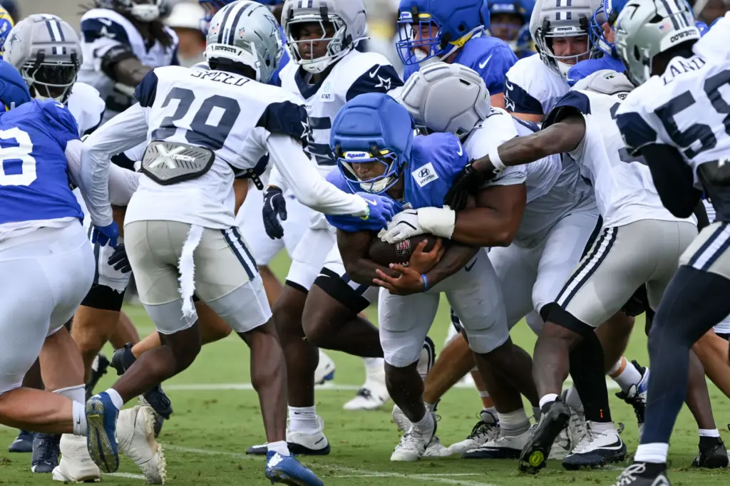 Rams running back Jarquez Hunter (27) gets wrapped up by...