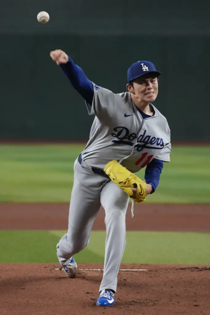 Dodgers starting pitcher Roki Sasaki throws to the plate during...