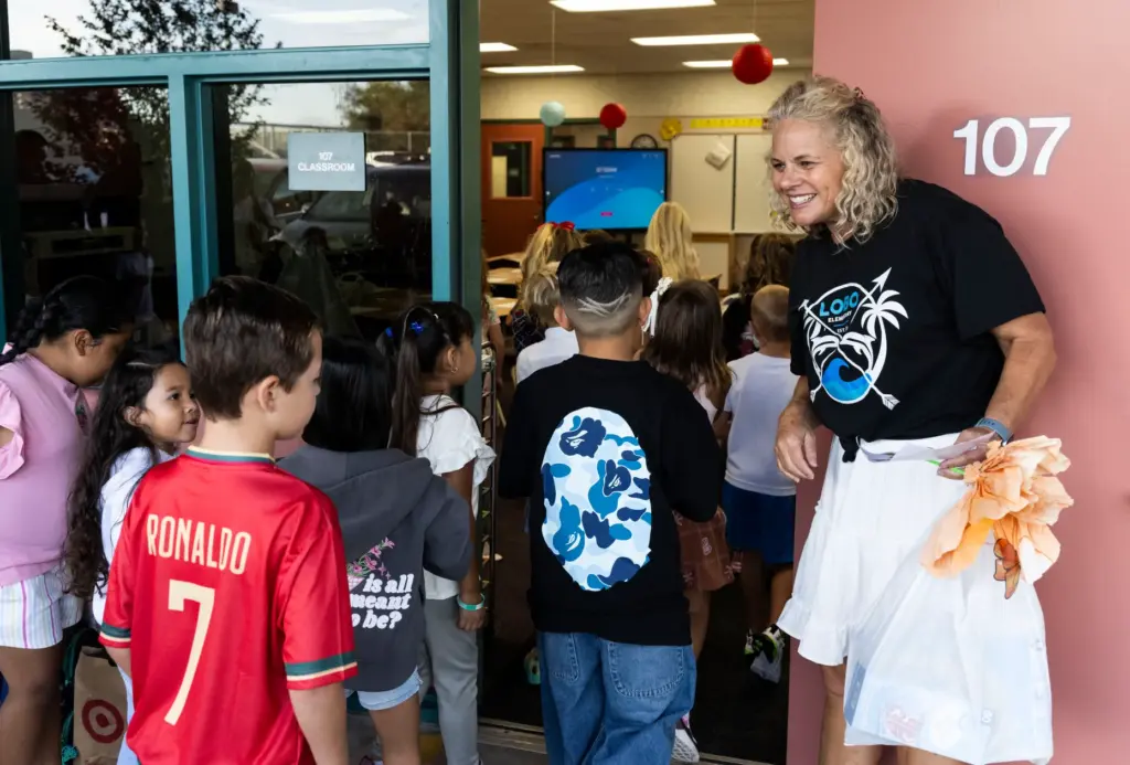 First-grade teacher Kelli Nye welcomes students during the first day...