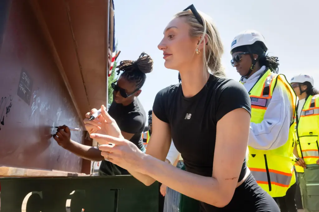 Cameron Brink, center, signs the final structural beam for the...