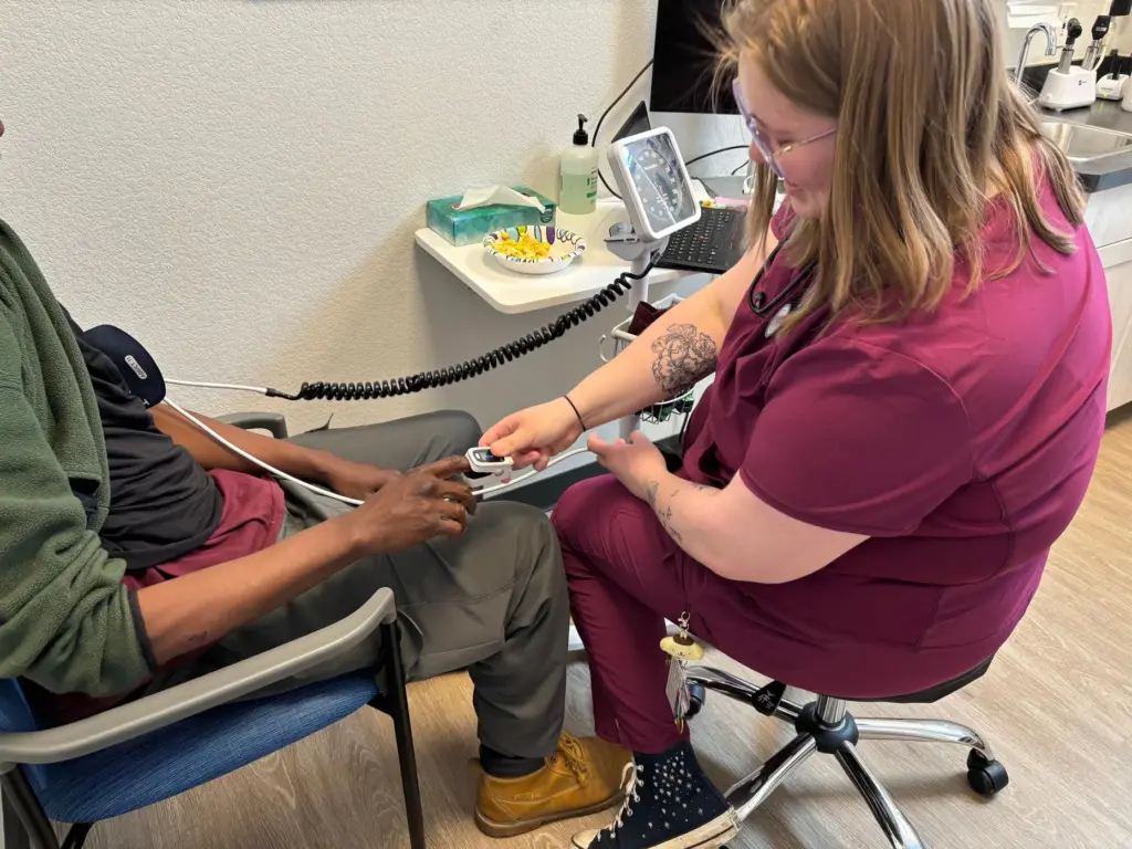 Izzy Kadrmas tests Tywon Pugh's blood oxygen saturation.