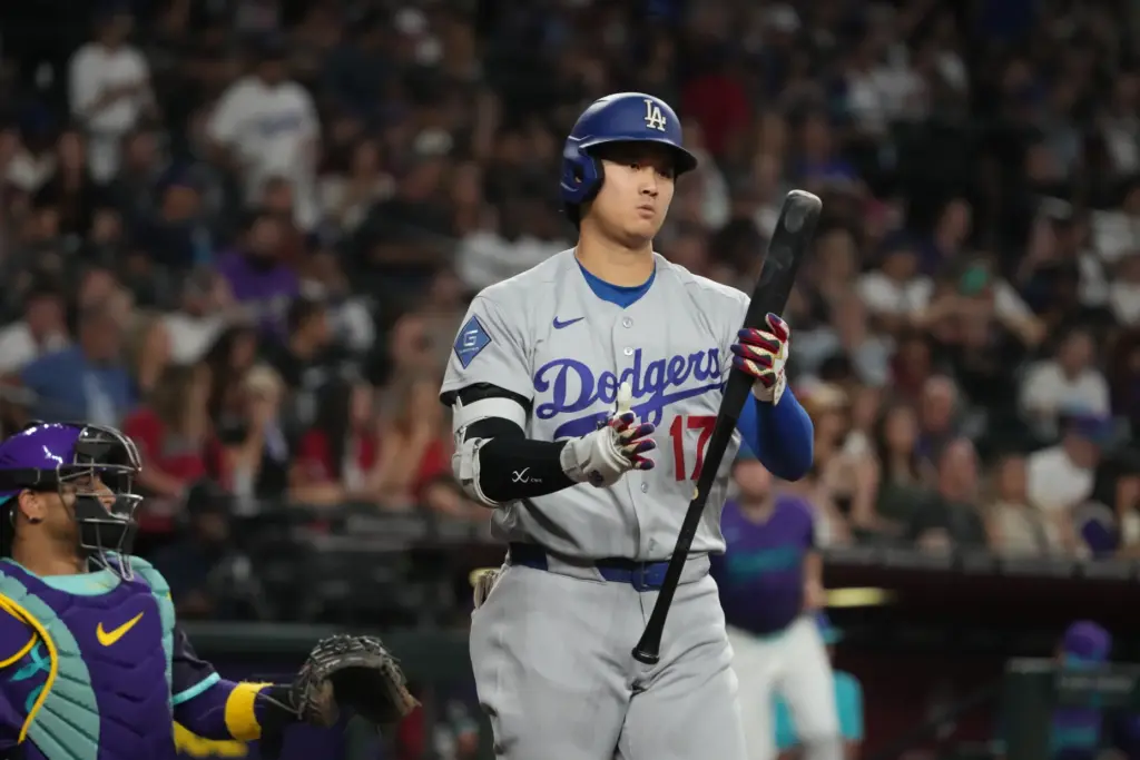 Dodgers star Shohei Ohtani looks at his bat after batting...