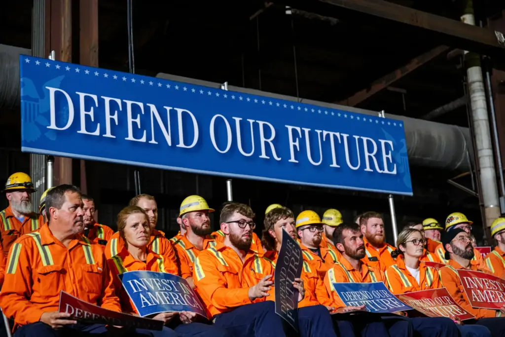 Workers hold signs and sit in stands ahead of Vice...
