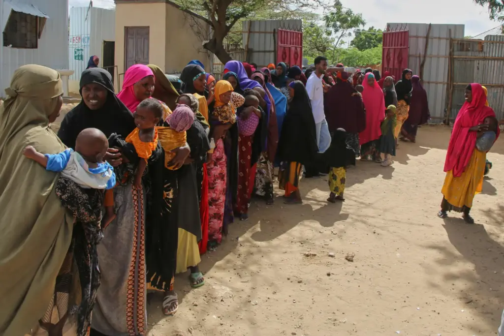 FILE – Somali women displaced by drought line up at...