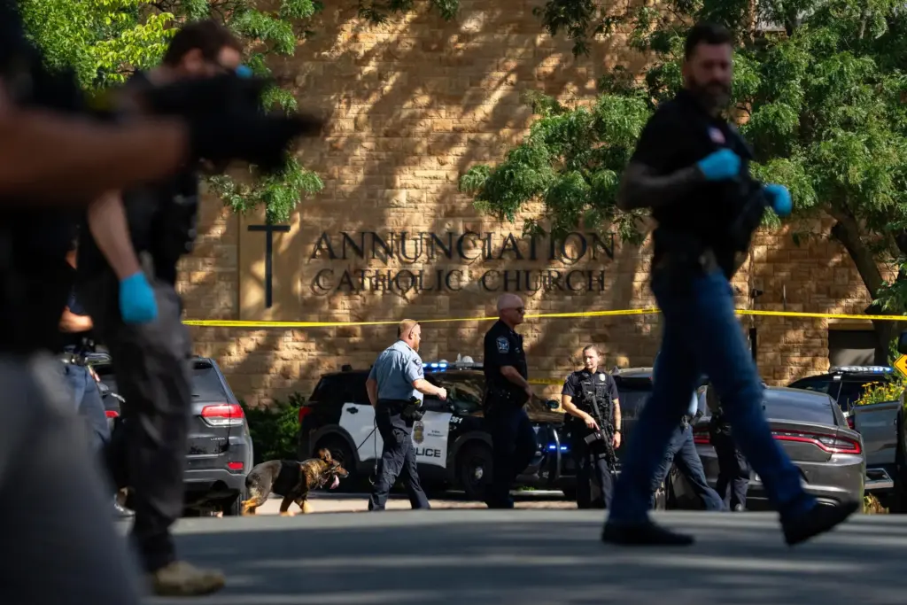 FILE – Law enforcement officers search the nearby neighborhood to...