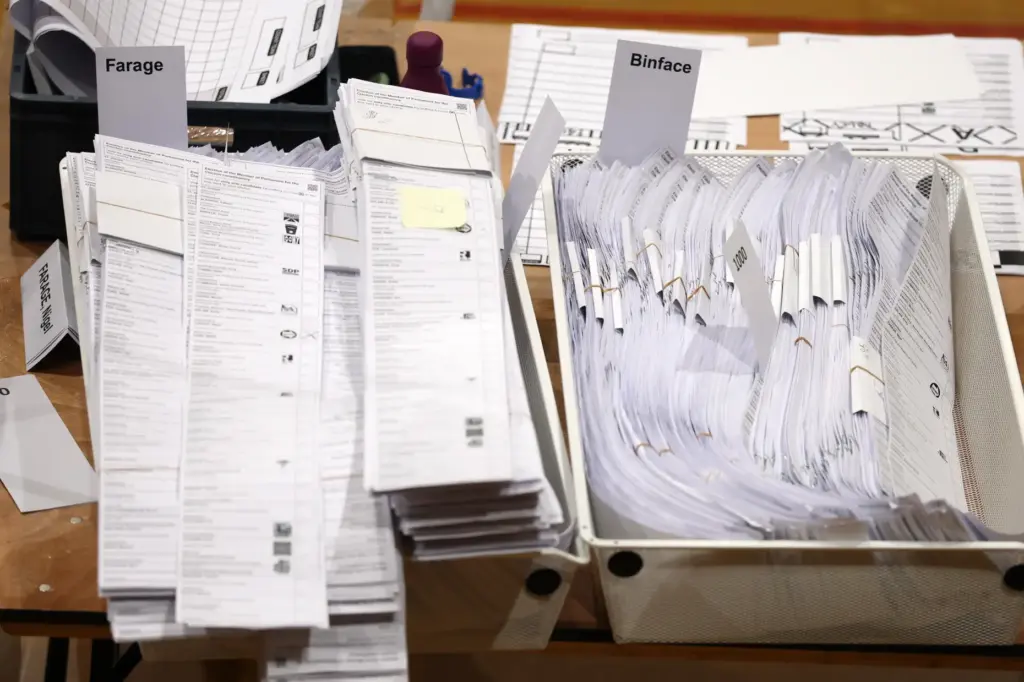 Ballot papers sorted for Farage and Binface are collected in boxes.