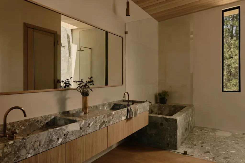 The primary bathroom finished in Grey Beauty marble with Studio...