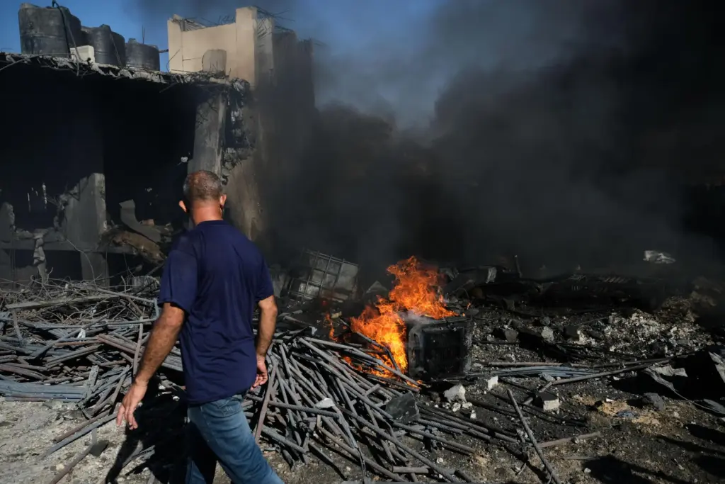 Palestinians inspect the rubble of a building destroyed in an...