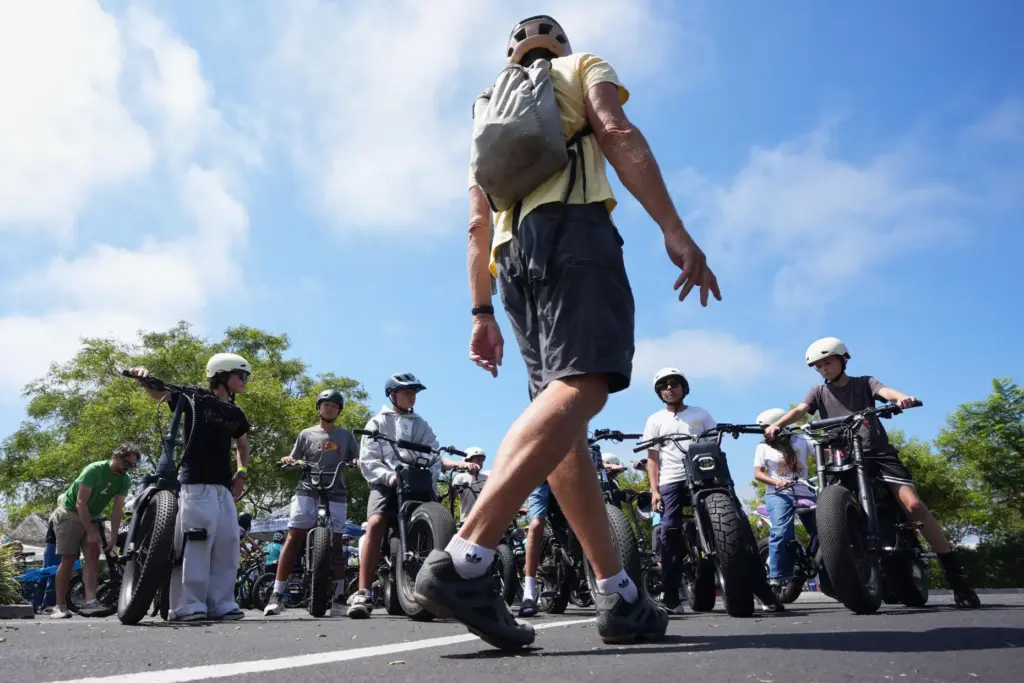 A group of riders listen to an instructor during an...