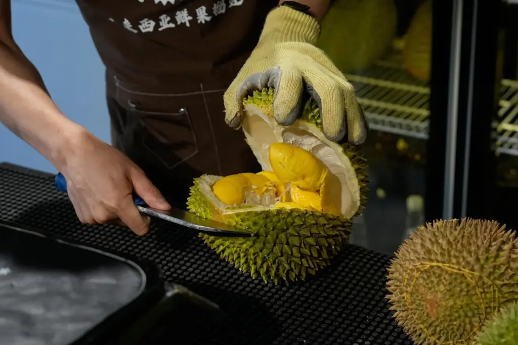 A worker opens durian fruits imported from Malaysia.
