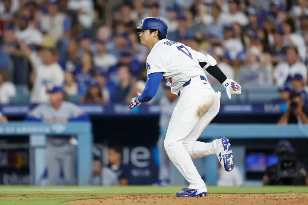 Dodgers star Shohei Ohtani runs to first base after hitting...
