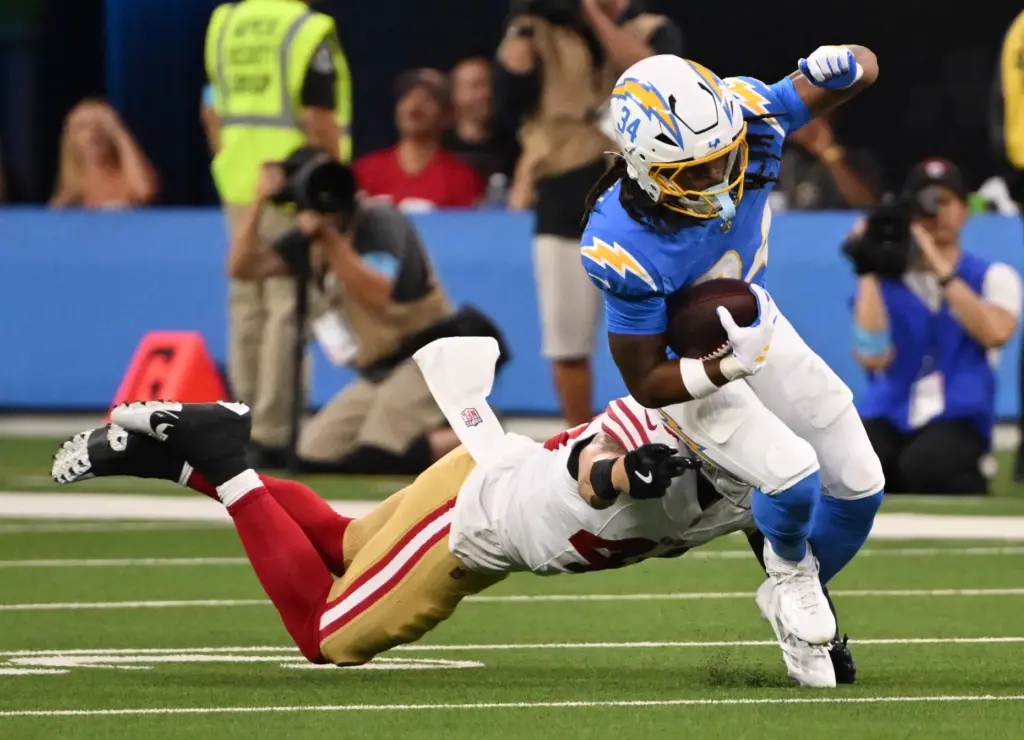 Chargers running back Keaton Mitchell, right, runs for a first...