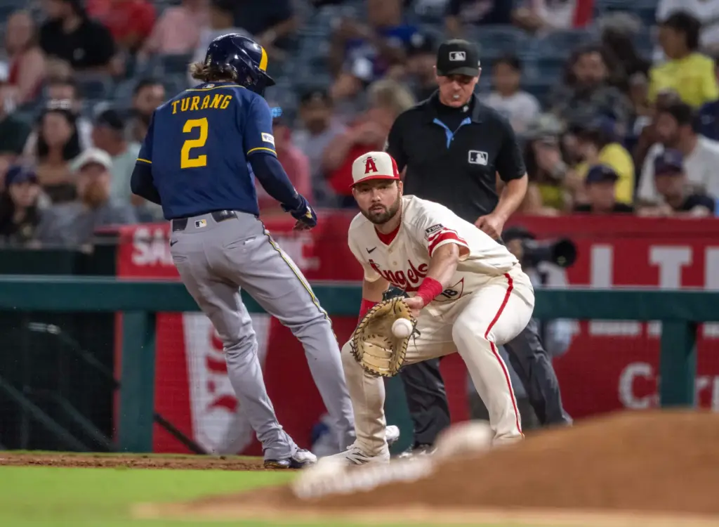 Milwaukee Brewers infielder Brice Turang (2) gets safely back to...