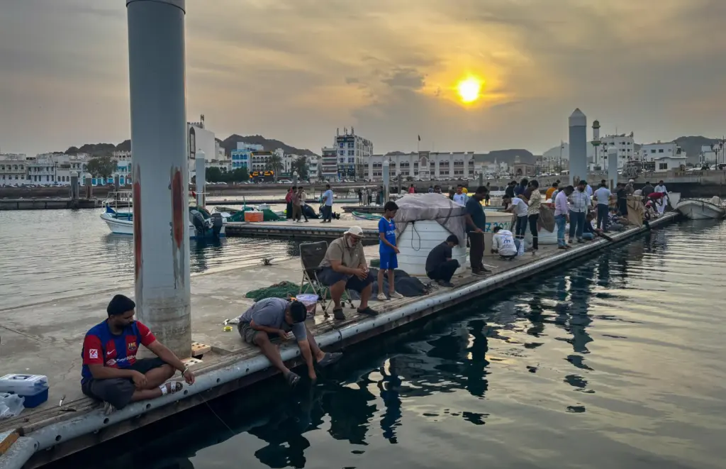 People fish along a pier near Mutrah Corniche in Muscat, Oman.