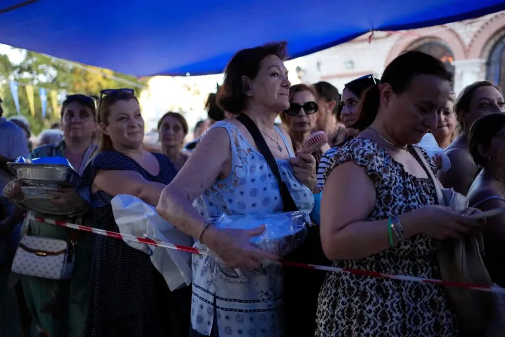 Pilgrims wait to have their Fanouropites, orange-flavored cakes, blessed.