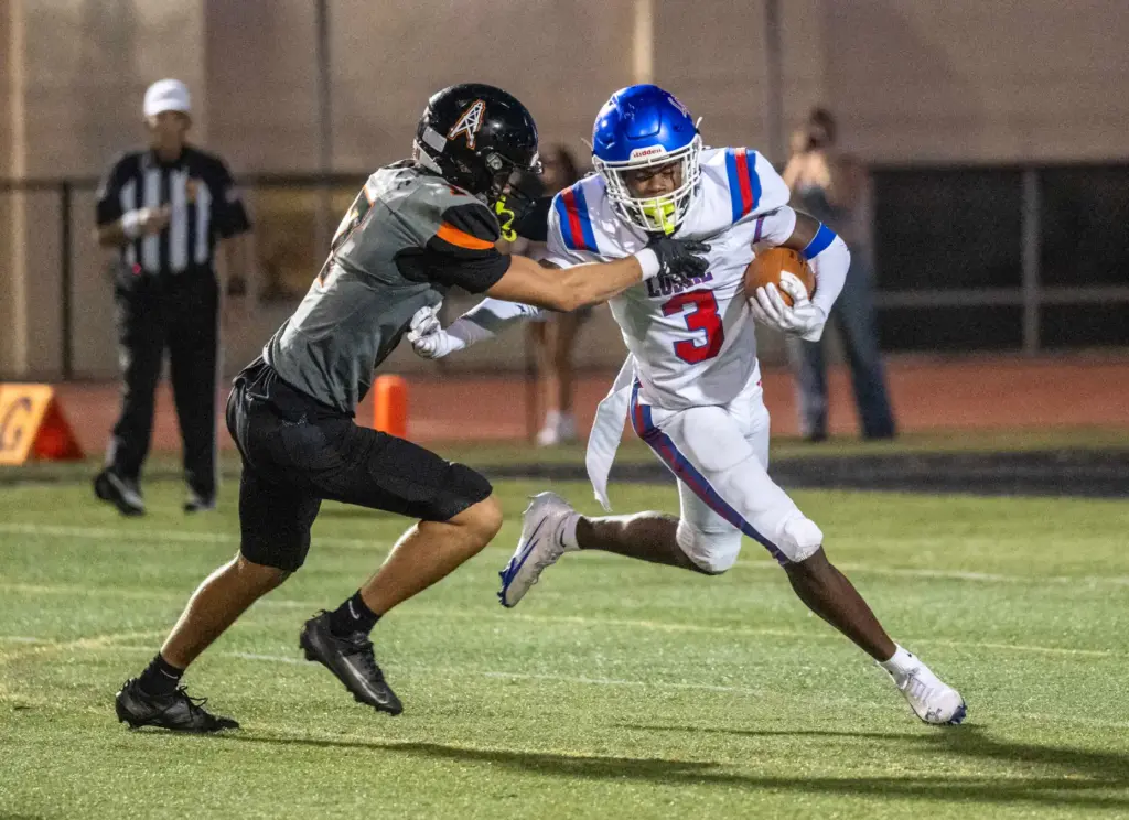 Los Alamitosâ Caeson Miller (3) breaks a tackle while carrying...