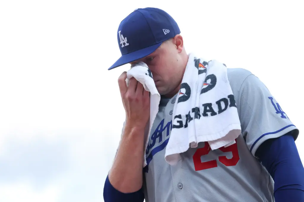 Dodgers starting pitcher Tarik Skubal wipes his face while walking...
