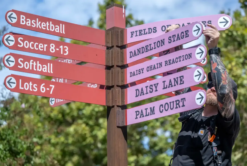 A worker adds decals over the regular Great Park signage...