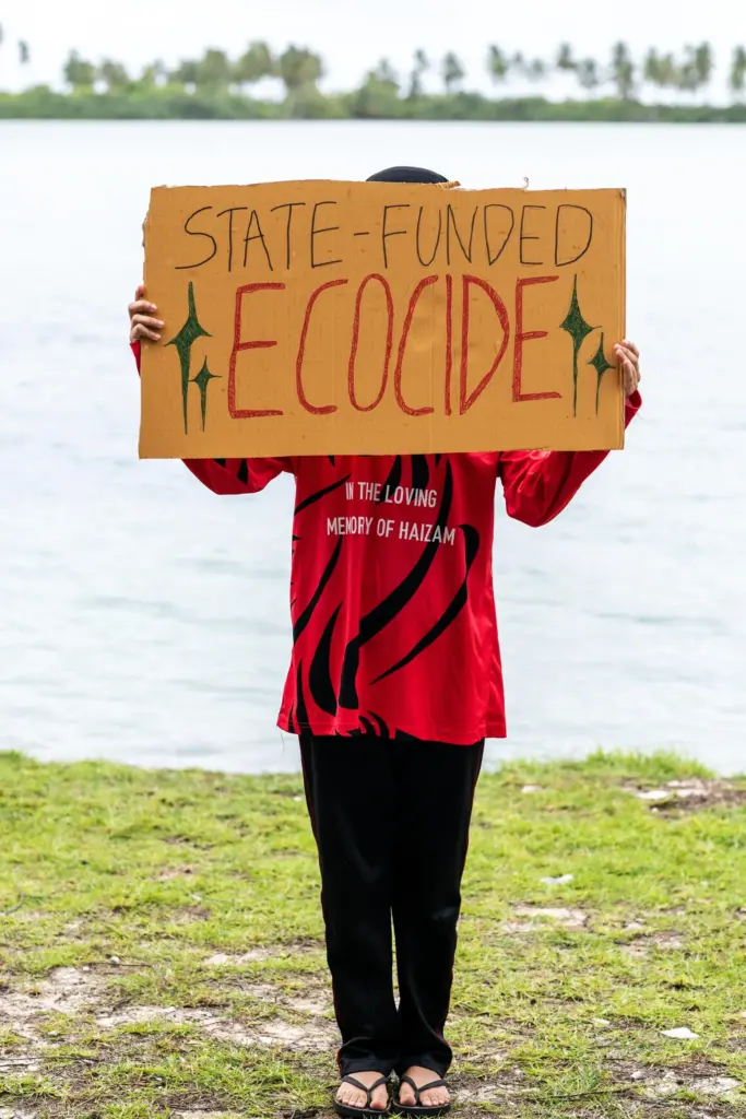 A demonstrator holds a sign while participating in an action...