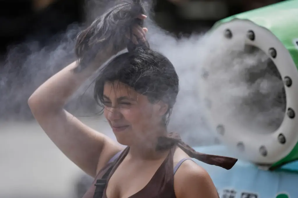 A person cools off at a cooling mist spot in Tokyo.