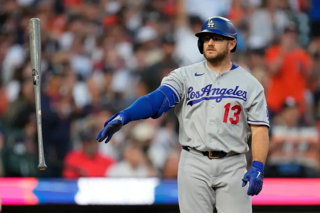 The Dodgers’ Max Muncy throws his bat in frustration after...