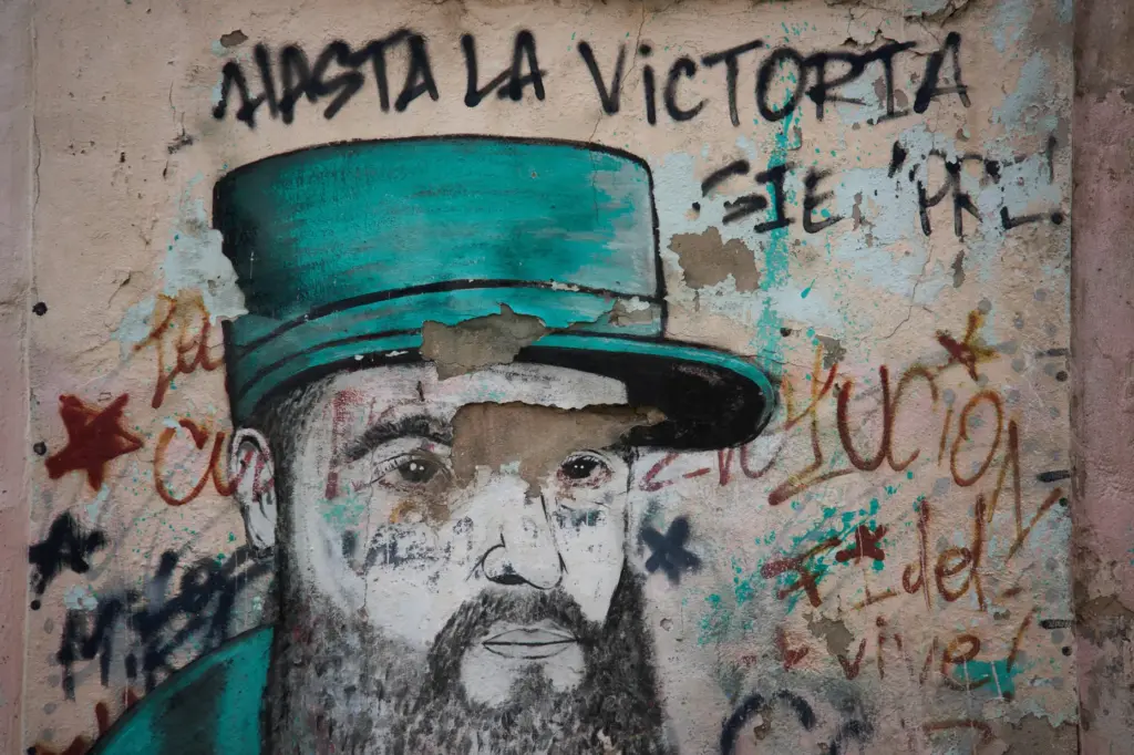 A weathered mural of Fidel Castro covers a wall in Havana, Cuba.