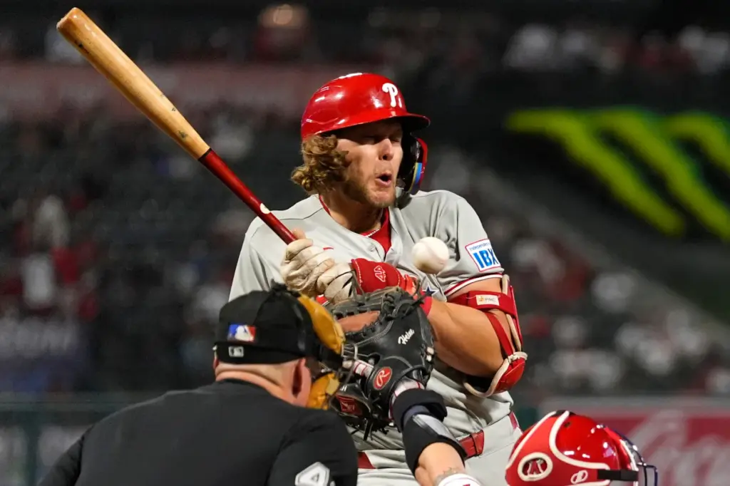 The Philadelphia Phillies’ Alec Bohm, center, is hit by a...