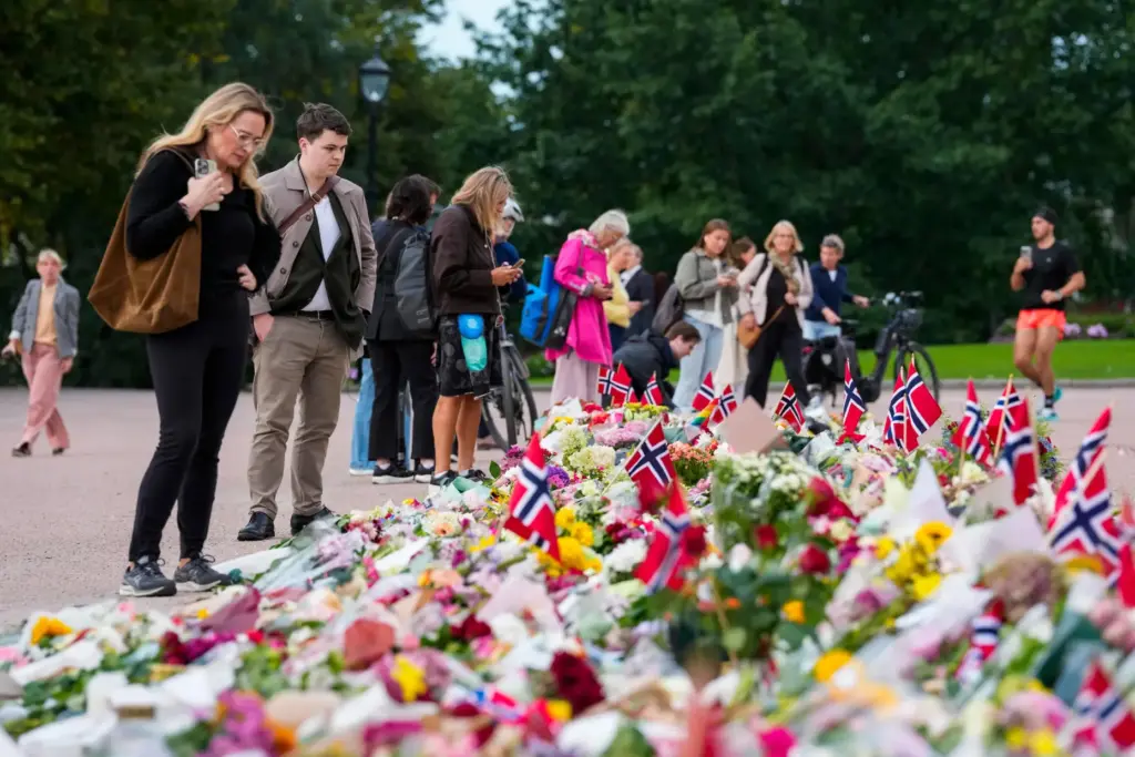 Flowers and Norway's flags are laid at the Palace Square in Oslo.