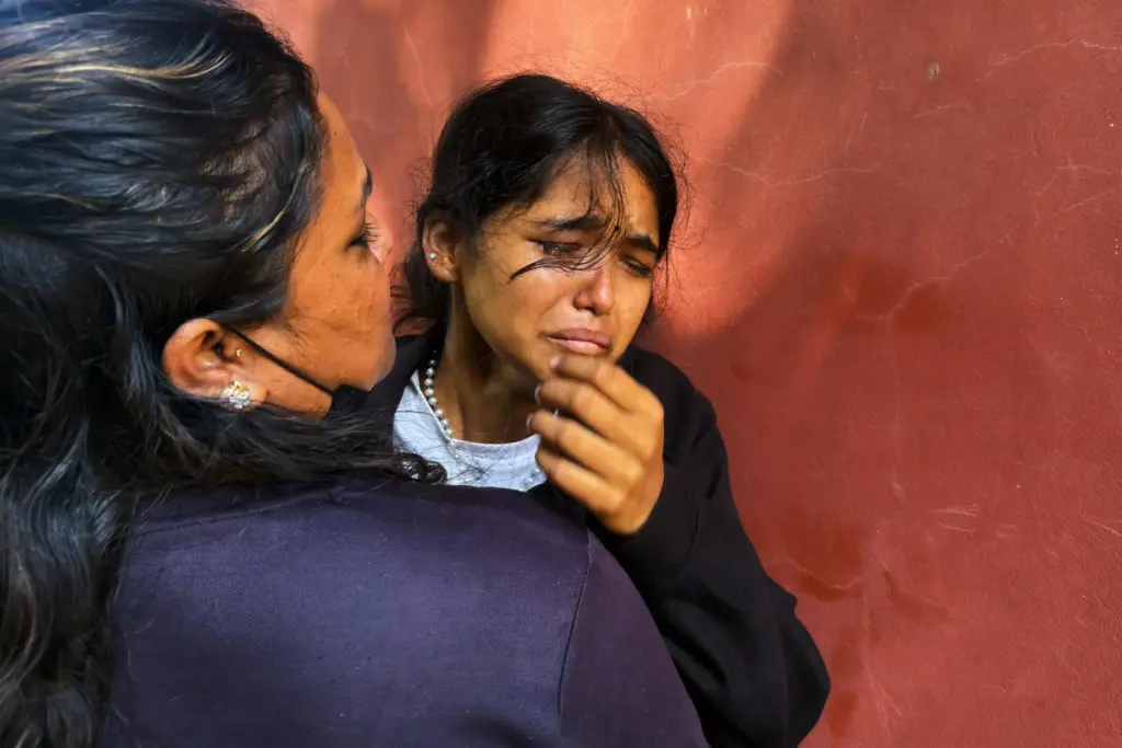 Jenisha cries as she waits for news on her father missing after flash flooding.