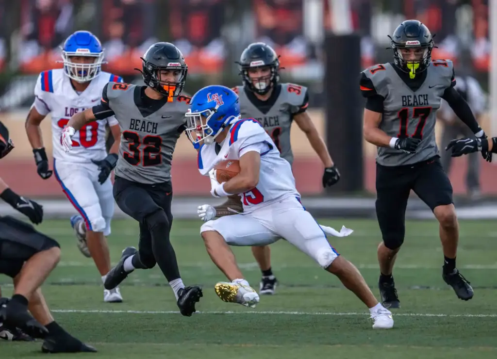 Los Alamitos wide receiver Ashton Gogue (13) carries the ball...