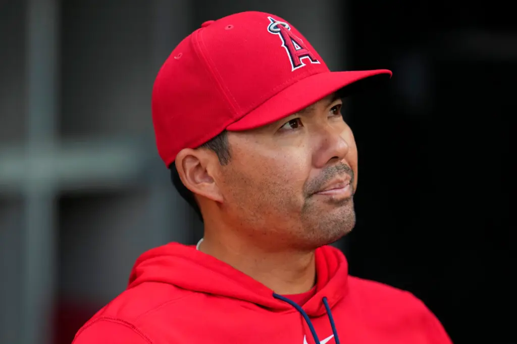 Angels manager Kurt Suzuki stands in the dugout during a...