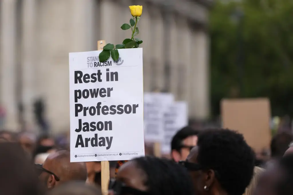 A sign is held during a vigil by Stand Up...