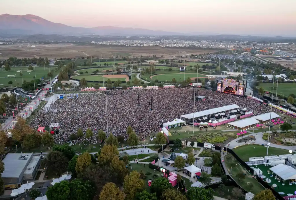 Thousands of festivalgoers fill the field in front of the...