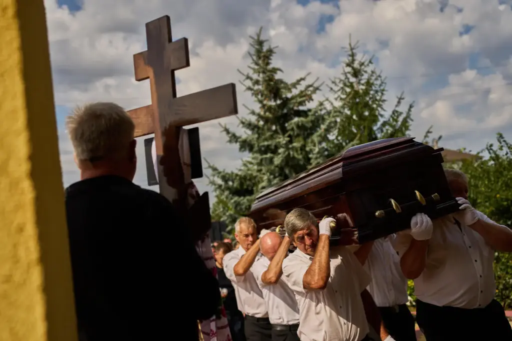Pallbearers carry the coffin of Taras Didych, head of the...