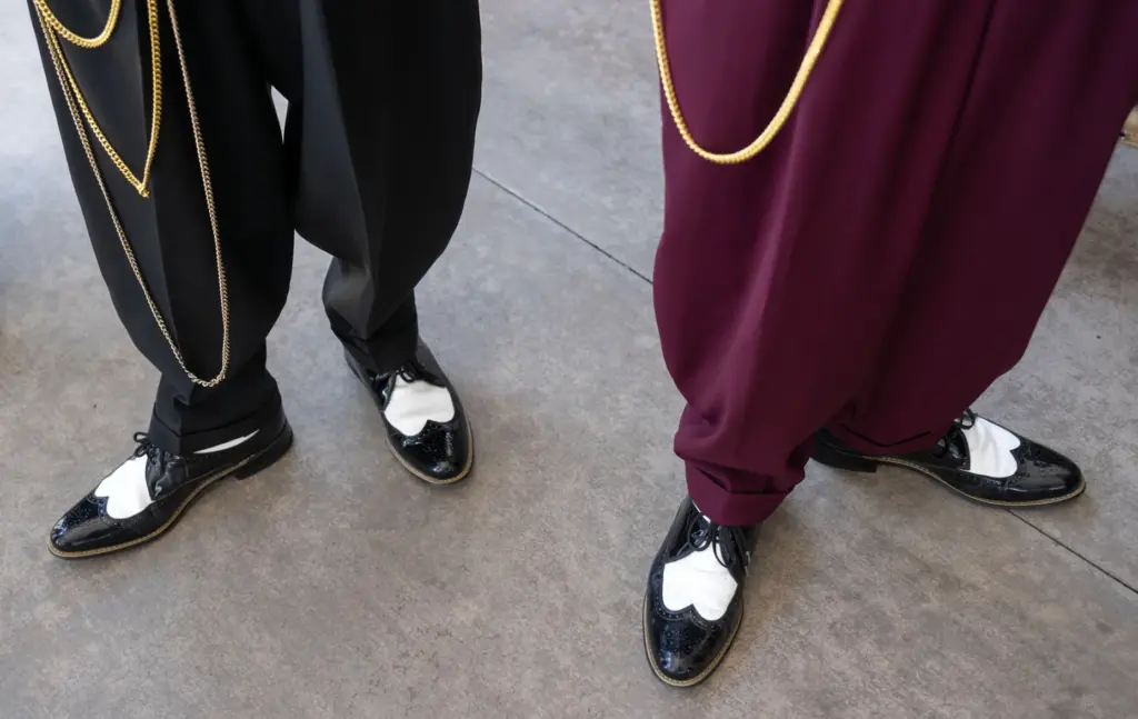 Models wear iconic black-and-white wing-tipped shoes that were worn with...