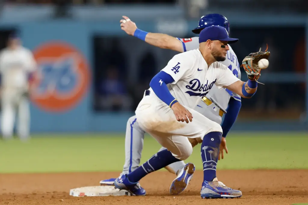 Dodgers second baseman Miguel Rojas, front, readies to catch the...