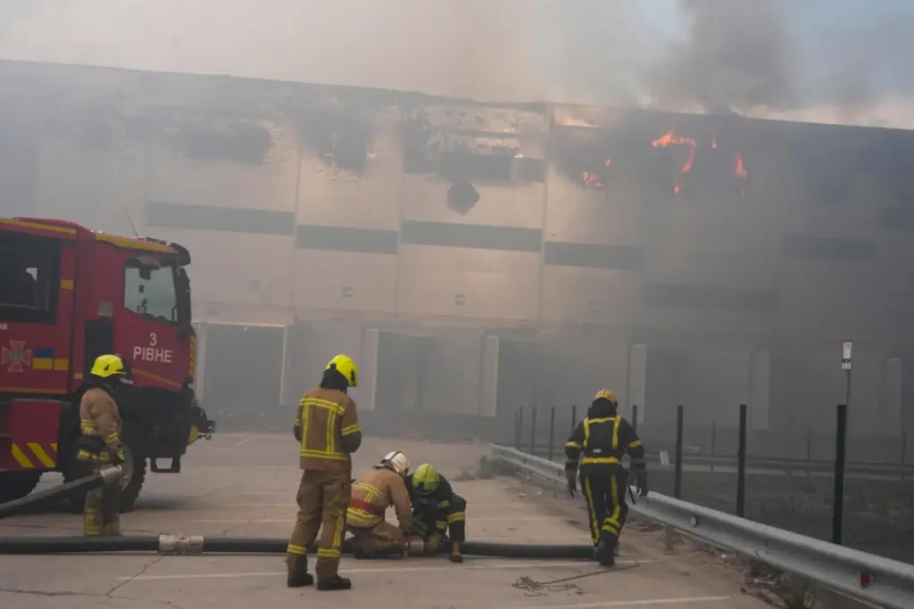 Firefighters put out a fire at warehouse stores after a Russian air attack.