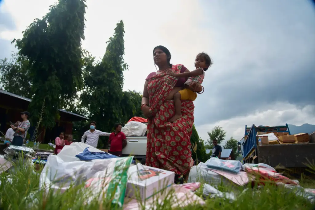 A flash flood survivor arrives to receive relief supplies in...