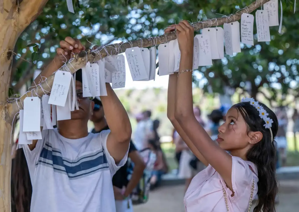 Festivalgoers tie messages onto âwish treesâ at an art installation...