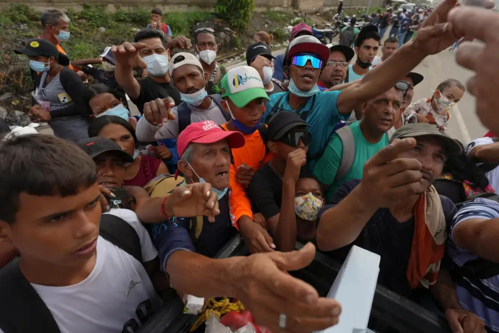 People reach out to receive supplies from volunteers, days after an earthquake struck La Guaira, Venezuela.