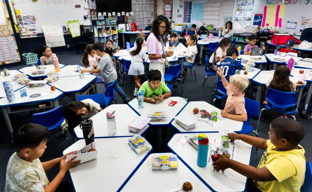 Second-grade teacher Sarai Lucero takes attendance as students eat breakfast...