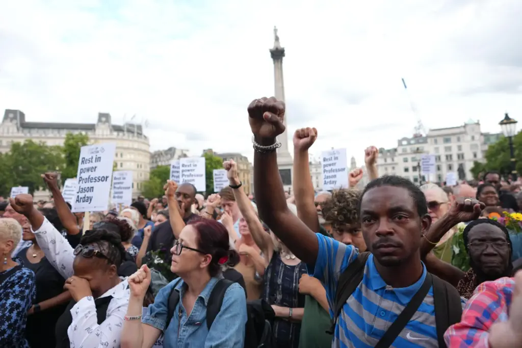 People gesture as they attend a vigil held by Stand...
