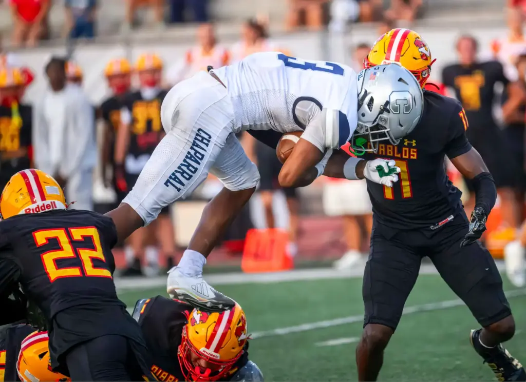 Chaparral wide receiver Eli Woodard jumps over Mission Viejo defenders...