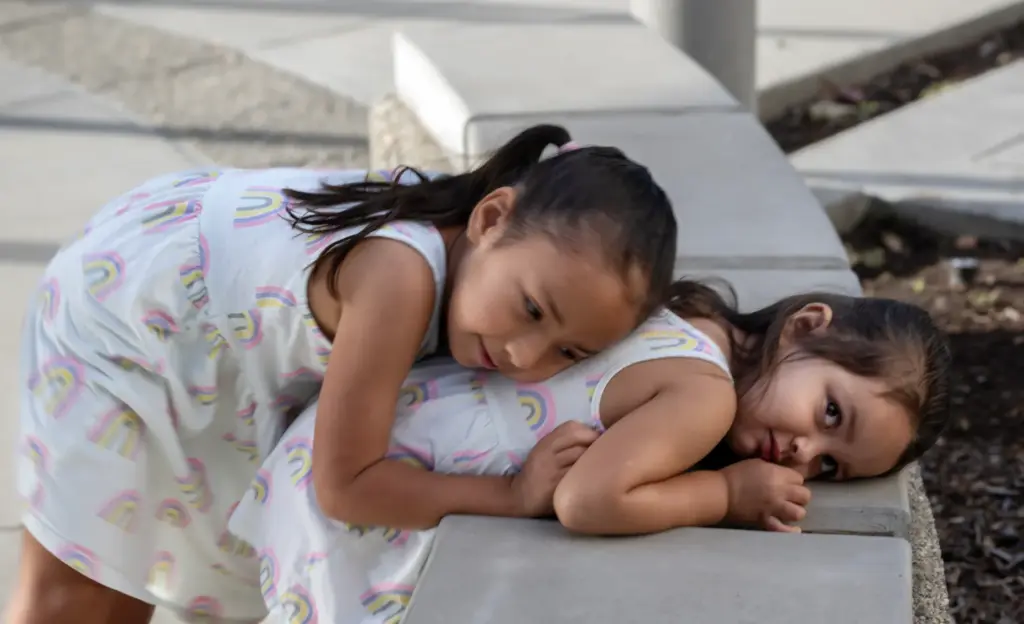 Millie Perez, 4, consoles her little sister, Izzy, 2, who...