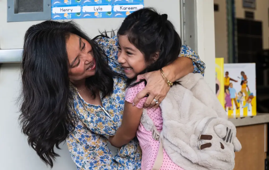 Valentina Olivar is hugged by her second-grade teacher Irene Takushi...