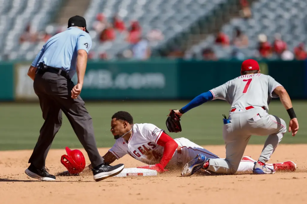 Angels’ Christian Moore (4), left, slides into second base as...