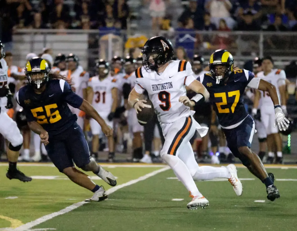 Huntington Beachs quarterback Brady Edmunds (9) tries to get past...