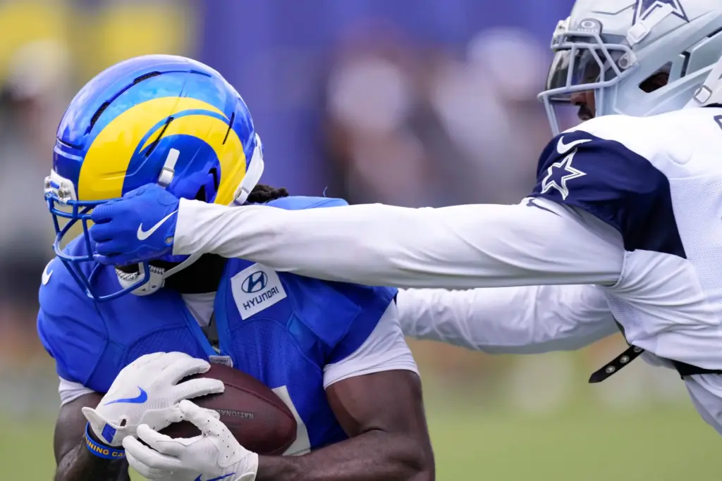 Rams wide receiver Mario Williams, left, has his facemask grabbed...