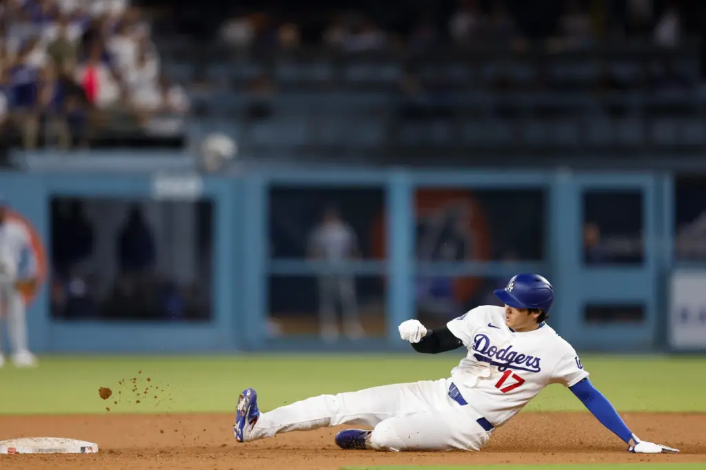 Dodgers star Shohei Ohtani slides as he steals second base...