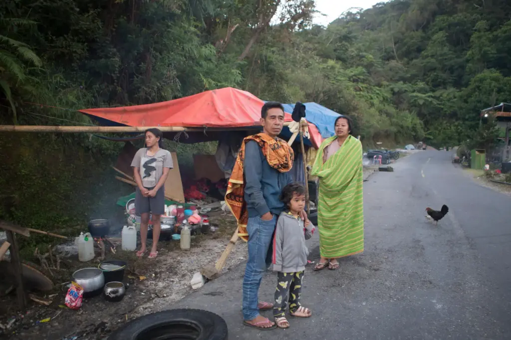 People take shelter in makeshift tent amid fears of aftershocks in Reo, Indonesia.